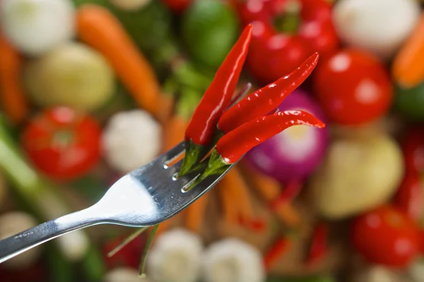 Red hot chilli peppers on fork — Stock Photo, Image