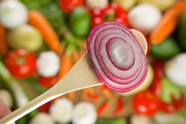 Red onion on a wooden spoon — Stock Photo, Image