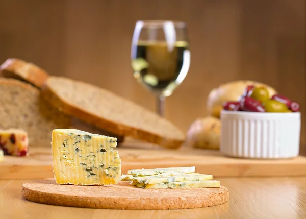 Blåmögelost med glas vin på en bakgrund — Stockfoto