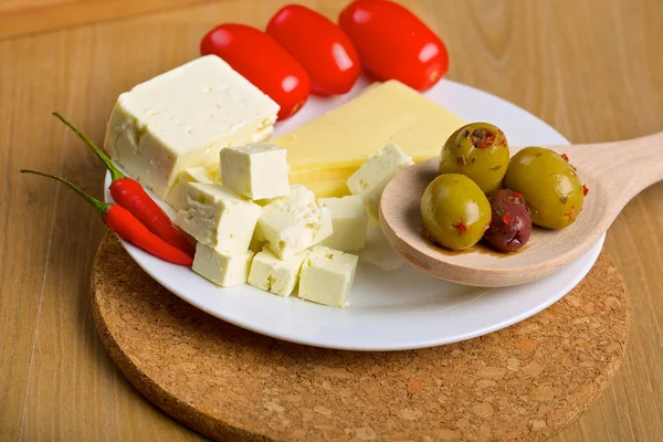 Oliver, ost och tomater på ett fat — Stockfoto