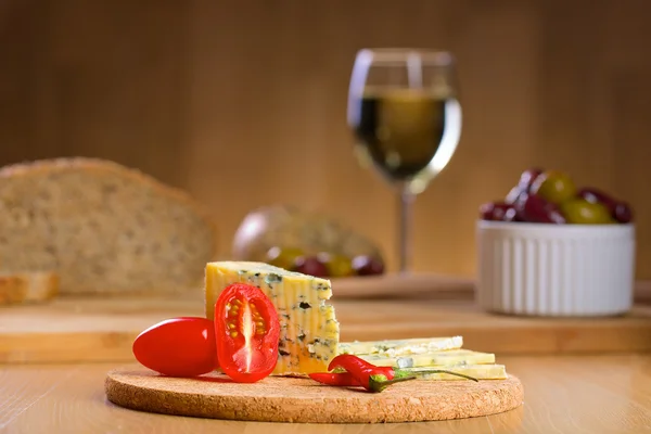 Blåmögelost med glas vin på en bakgrund — Stockfoto