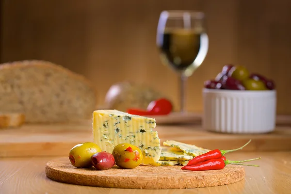 Blåmögelost med glas vin på en bakgrund — Stockfoto