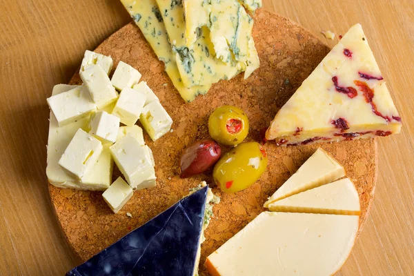 Olika ost och Oliver på en planka — Stockfoto
