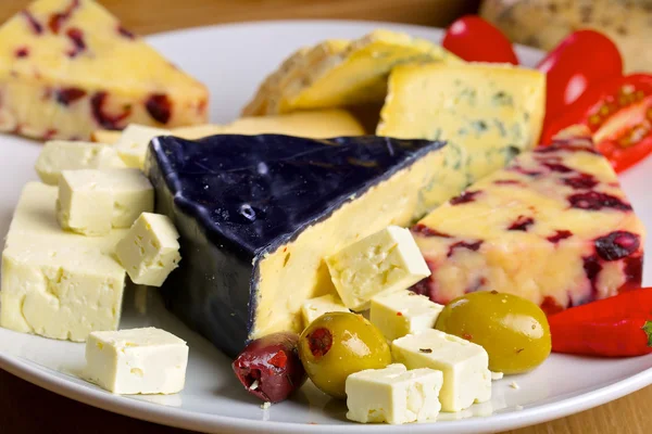 Olika ost och Oliver på en planka — Stockfoto