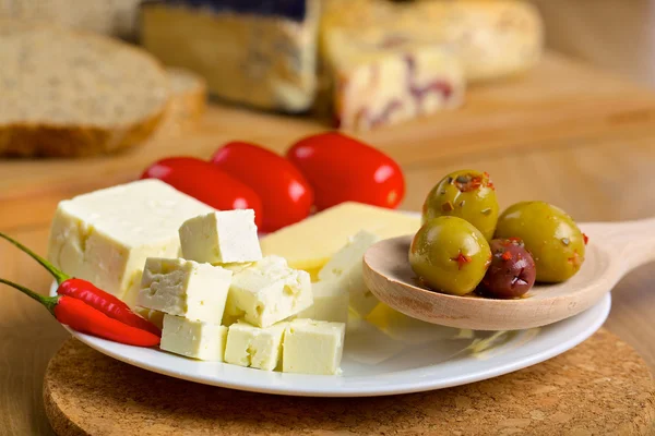 Queijo feta, azeitonas e tomates em um prato — Fotografia de Stock