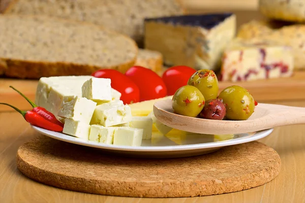 Queijo feta, azeitonas e tomates em um prato — Fotografia de Stock