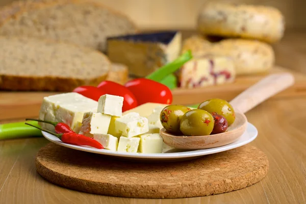 Queijo feta, azeitonas e tomates em um prato — Fotografia de Stock