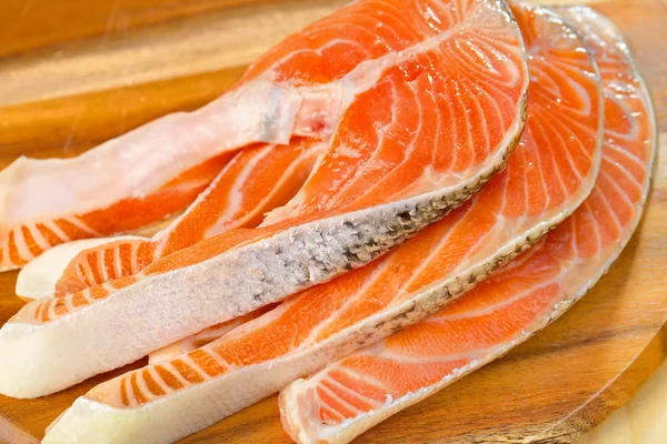 Délicieuse portion de filet de saumon frais sur une table en bois — Photo
