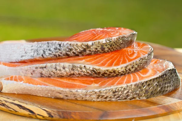 Delicious  portion of fresh salmon fillet on a wooden table — Stock Photo, Image