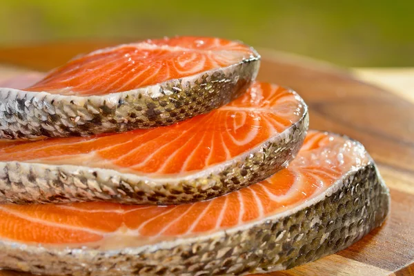 Delicious  portion of fresh salmon fillet on a wooden table — Stock Photo, Image