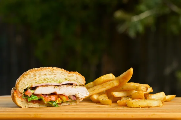 Zmontowalem hamburgera z serem i grubości podłoża soczysty kurczak patty, sałata, pomidor, cebula, sezam bułka stojąc na drewnianym stole — Zdjęcie stockowe
