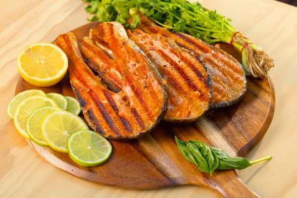 Grilovaný filet z lososa s limetkou a petržel na dřevěném prkénku — Stock fotografie