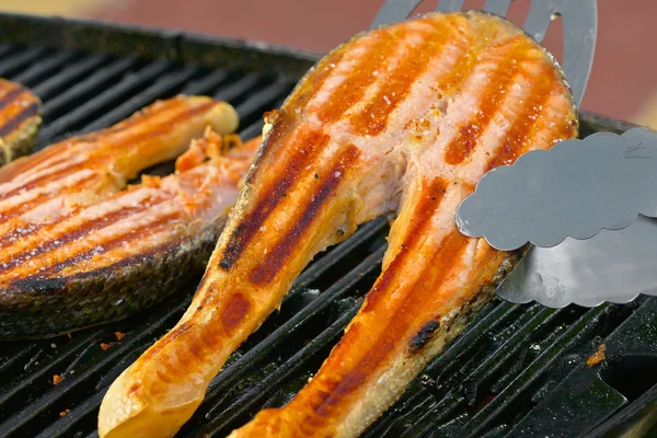 Portion of fresh salmon fillet on a grill — Stock Photo, Image