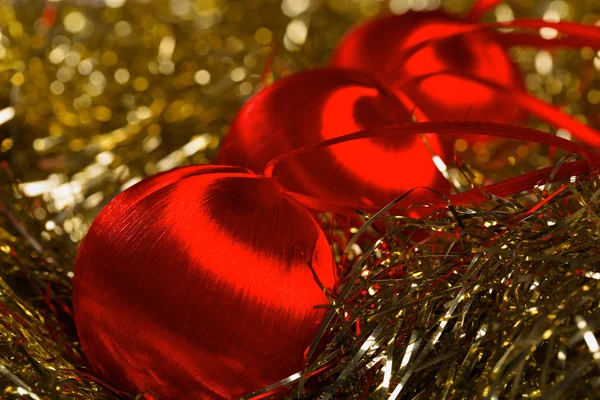 Red christmas balls on yellow tinsel — Stock Photo, Image