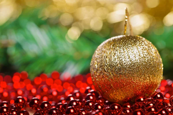 Gelbe Weihnachtskugel auf roten Perlen — Stockfoto