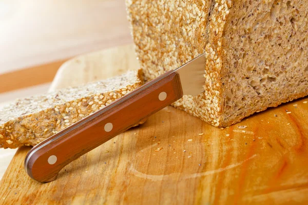 Cutted rye bread loaf on wooden table — Stock Photo, Image