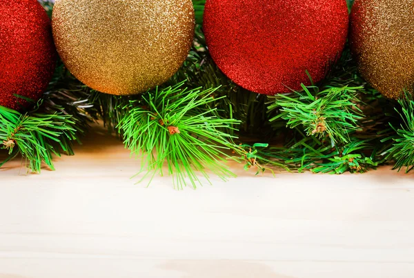 Christmas balls with fir-tree branches on wooden background — Stock Photo, Image