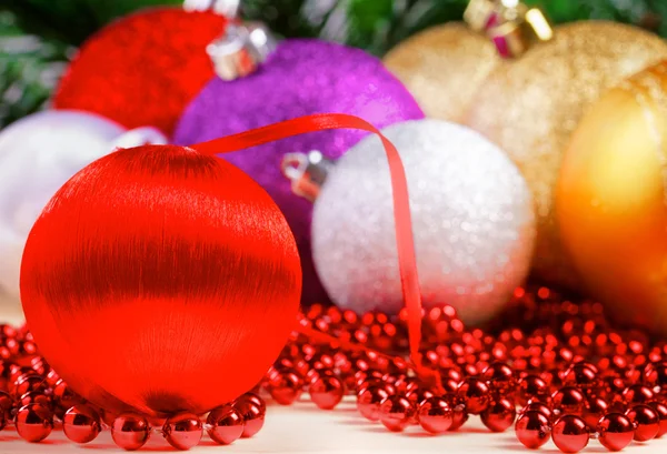 Variety of christmas balls on red beads decoration — Stock Photo, Image