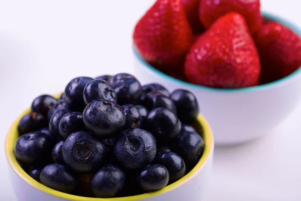 Blueberry and strawberry in white cans — Stock Photo, Image