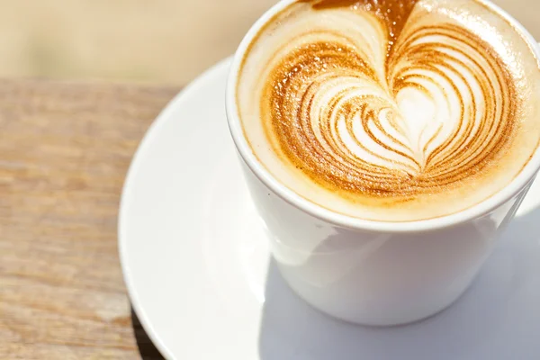 Cappuchino or latte coffe in a white cup with heart shaped foam — Stock Photo, Image