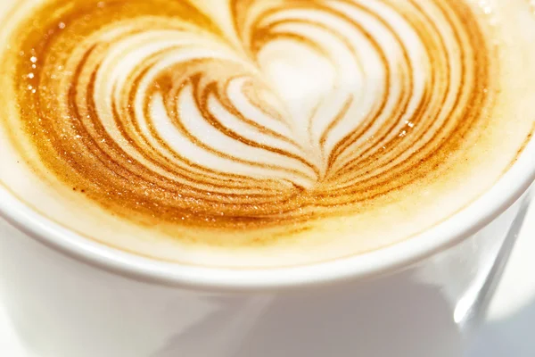 Cappuchino or latte coffe in a white cup with heart shaped foam — Stock Photo, Image