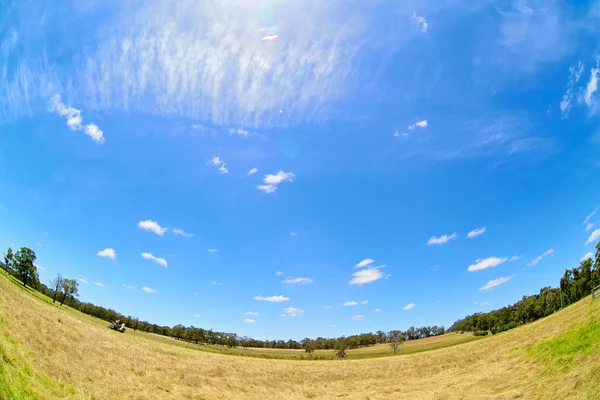 Australische Feldlandschaft mit Heuhaufen und blauem Himmel. Fischaugenlinse — Stockfoto