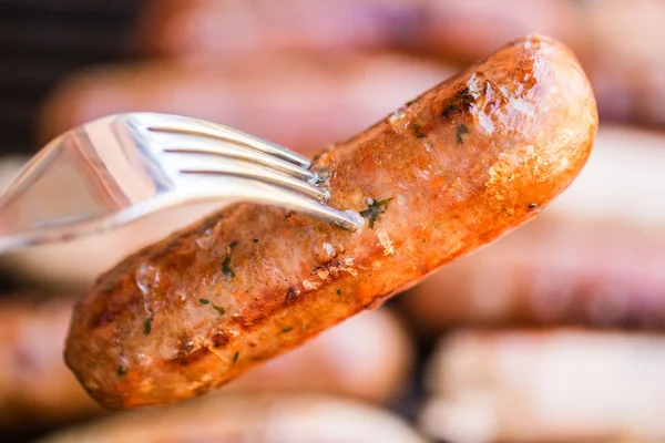 Barbecued beef and pork sausage on fork — Stock Photo, Image