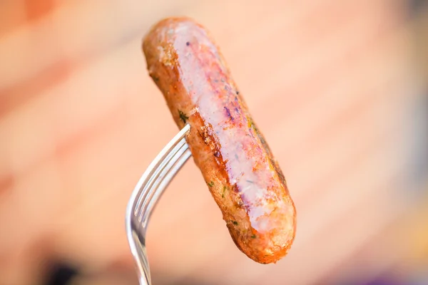 Barbecued beef and pork sausage on fork — Stock Photo, Image