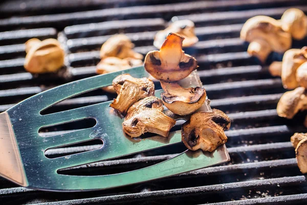 Grilled champignon mushrooms on spatula — Stock Photo, Image