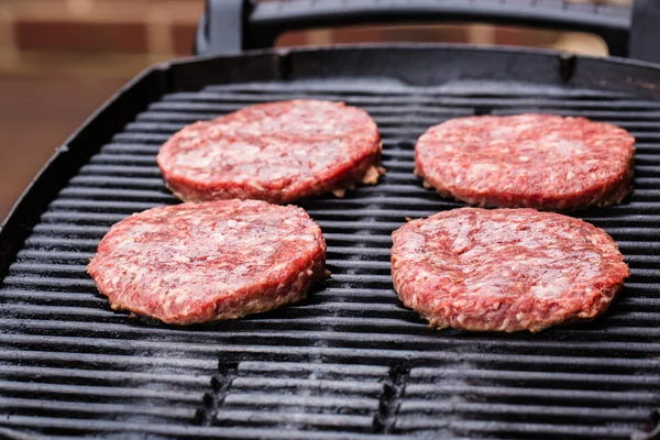 Preparando um lote de rissóis de carne moída grelhados ou frikadeller no churrasco — Fotografia de Stock