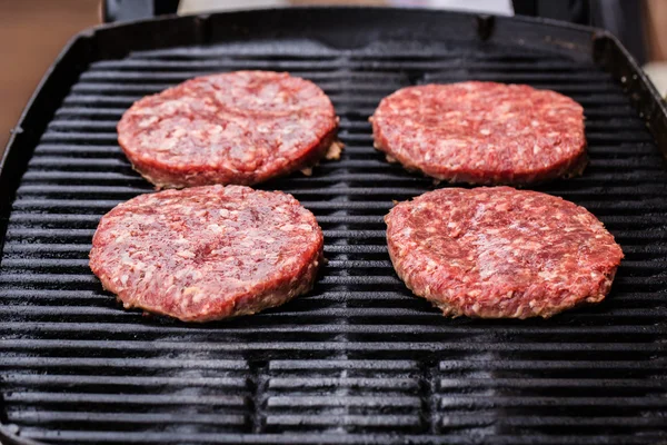 Pregătirea unui lot de patties de carne de vită măcinată la grătar sau frikadeller pe BBQ — Fotografie, imagine de stoc