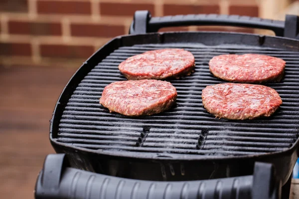 Preparación de un lote de empanadas de carne molida a la parrilla o frikadeller en la barbacoa —  Fotos de Stock