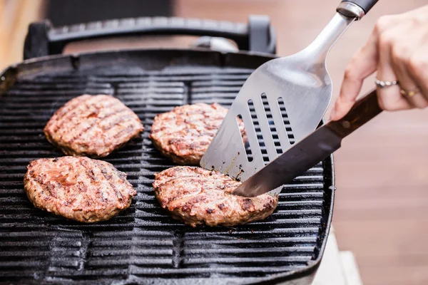 Hamburger di polpette di manzo alla griglia con spatola e coltello sul barbecue — Foto Stock