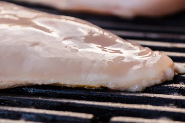 Raw chicken breast fillets on BBQ or grill — Stock Photo, Image