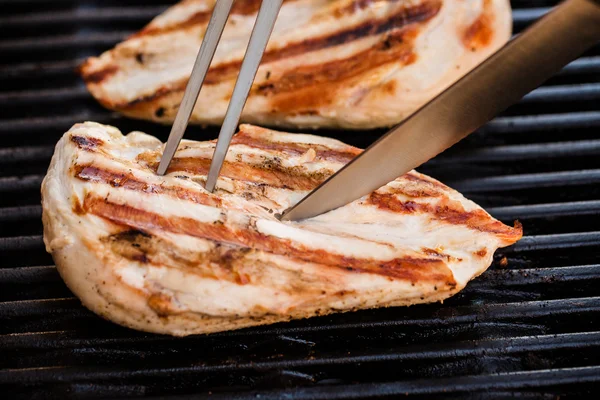 Grilled chicken breast fillets on BBQ with fork and knife — Stock Photo, Image