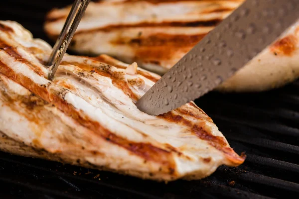 Filetes de peito de frango grelhado no churrasco com garfo e faca — Fotografia de Stock