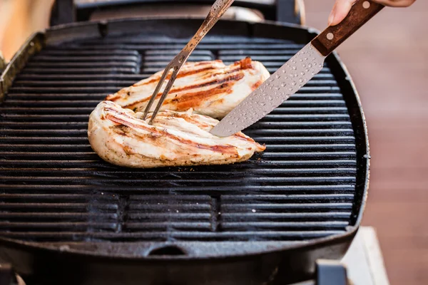 Filetti di petto di pollo alla griglia su barbecue con forchetta e coltello — Foto Stock