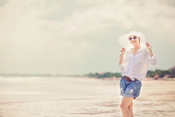 Młoda kobieta trzymać spaceru wzdłuż plaży w słoneczny dzień enjoing wakacji — Zdjęcie stockowe