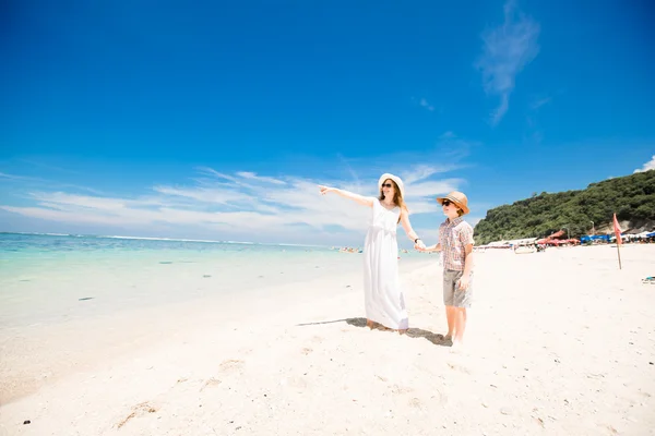 Feliz hermosa joven madre e hijo disfrutando de tiempo de playa con cielo azul sobre el océano en backgrund —  Fotos de Stock