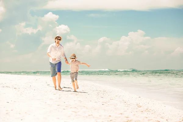 Šťastný otec a syn si pochutnávají čas na pláži na letní prázdniny — Stock fotografie
