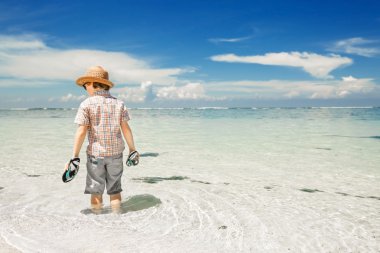 Şapka ve güneş gözlüğü takıyor güzel sahilde okyanus su içinde kalan mutlu genç çocuk.