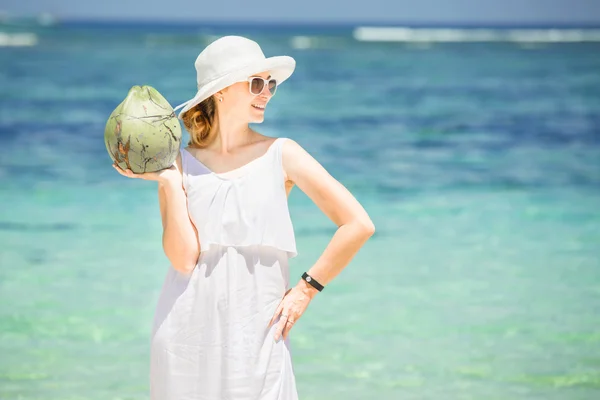 Beautiful young woman holding and drinkind a coconut fresh cocktail in tropical sea — Stock Photo, Image