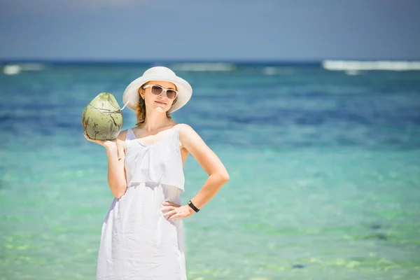 Piękna młoda kobieta trzyma i drinkind kokos koktajl świeże tropikalne morze — Zdjęcie stockowe
