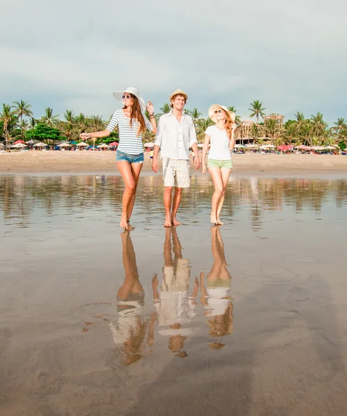 Groep van gelukkige jonge mensen lopen langs het strand op een mooie zomerse zonsondergang — Stockfoto