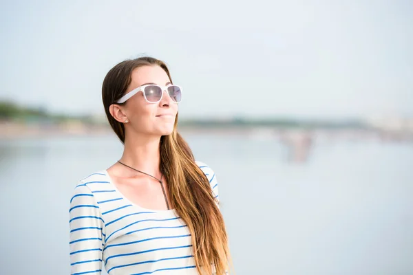 Beautiful young woman walking along the beach at sunset enjoing summer vacation — стоковое фото