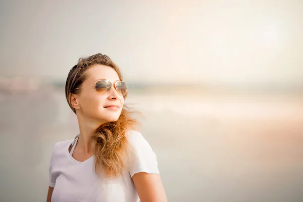 BEAUTIFIL ung kvinna promenerar längs stranden i solnedgången ordnade sommarsemester — Stockfoto