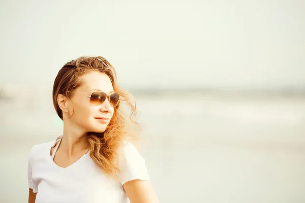 Beautifil joven mujer caminando a lo largo de la playa al atardecer disfrutando de vacaciones de verano — Foto de Stock