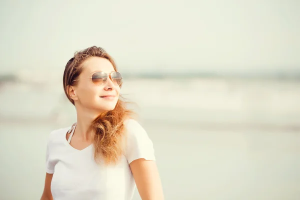 Beautifil joven mujer caminando a lo largo de la playa al atardecer disfrutando de vacaciones de verano — Foto de Stock