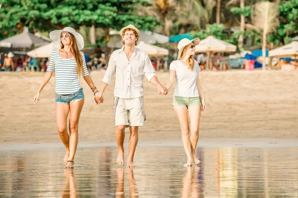 Skupina happy mladých lidí, procházky po pláži na krásné letní západ slunce — Stock fotografie