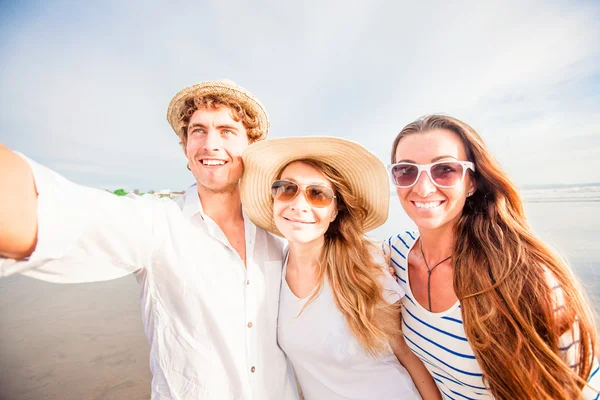 Gruppo di giovani felici che si fanno selfie sulla spiaggia — Foto Stock